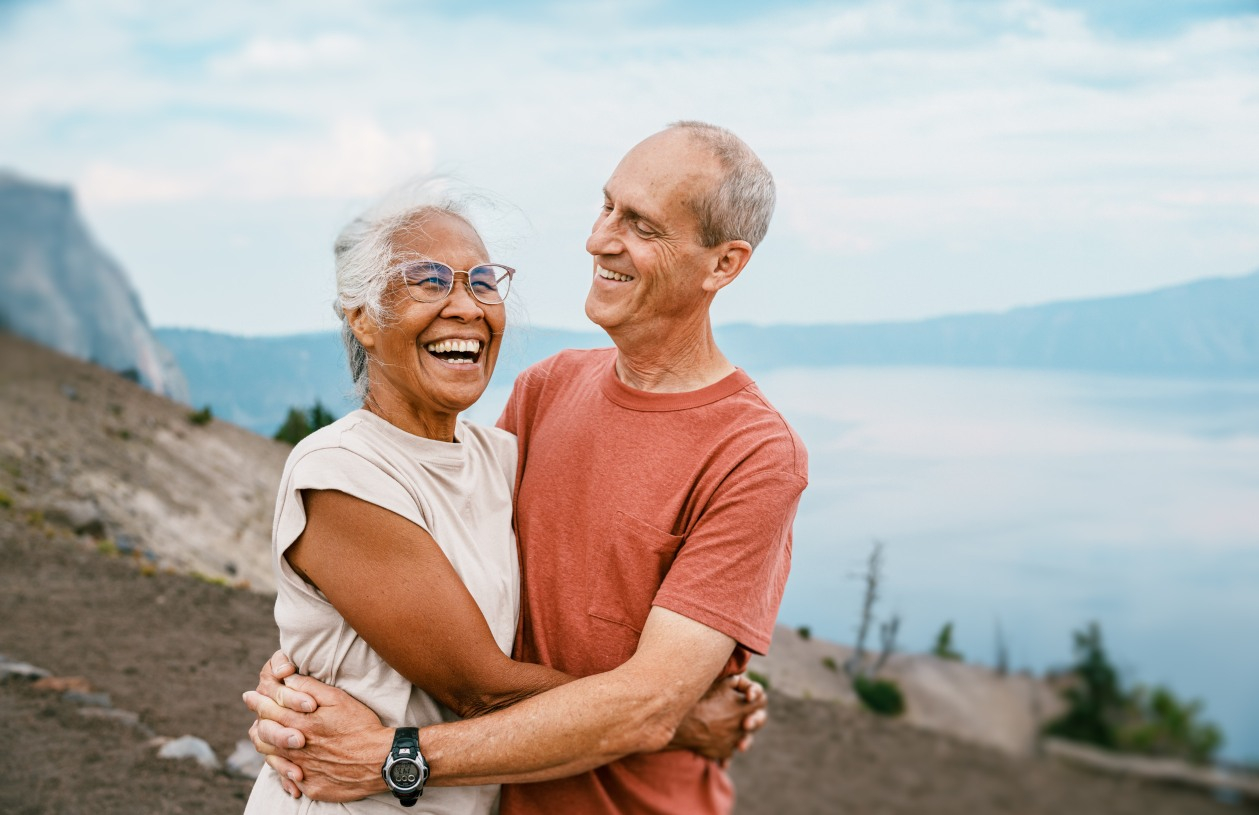 A happy retired couple smiling on a hike