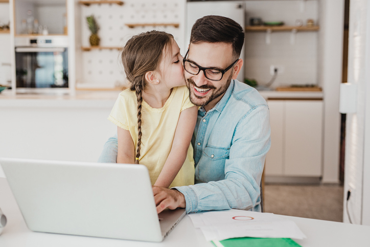 Father and young daughter happily look at the interest she is earning on her kids savings account at Alliant.
