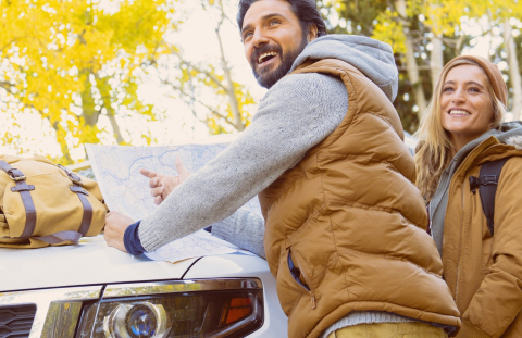 Happy couple load up their new car with hiking gear after getting credit union car loan.
