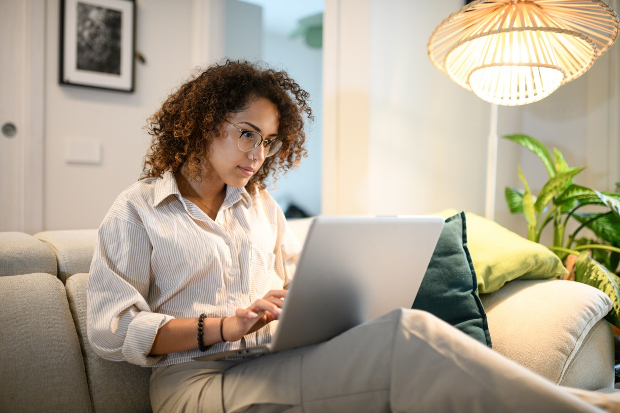 A woman oversharing with AI on her laptop at home.