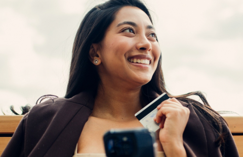 Young woman happily pays down her credit card debt with her tax refund.