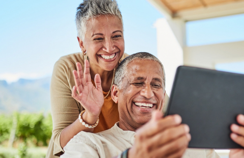 Retired couple review their Social Security and Medicare benefits on their tablet on their back patio. 