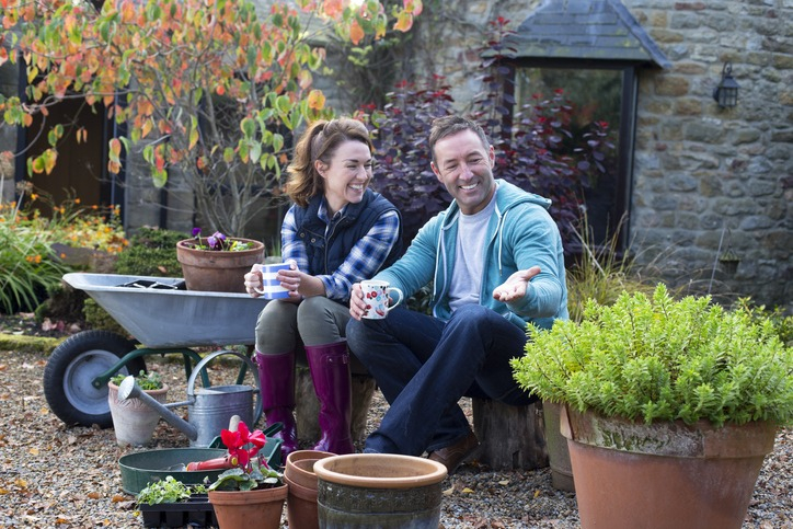 Happy couple works in their new home's garden. 