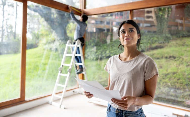 Woman happily renovates her home thanks to a home equilty line of credit (HELOC).