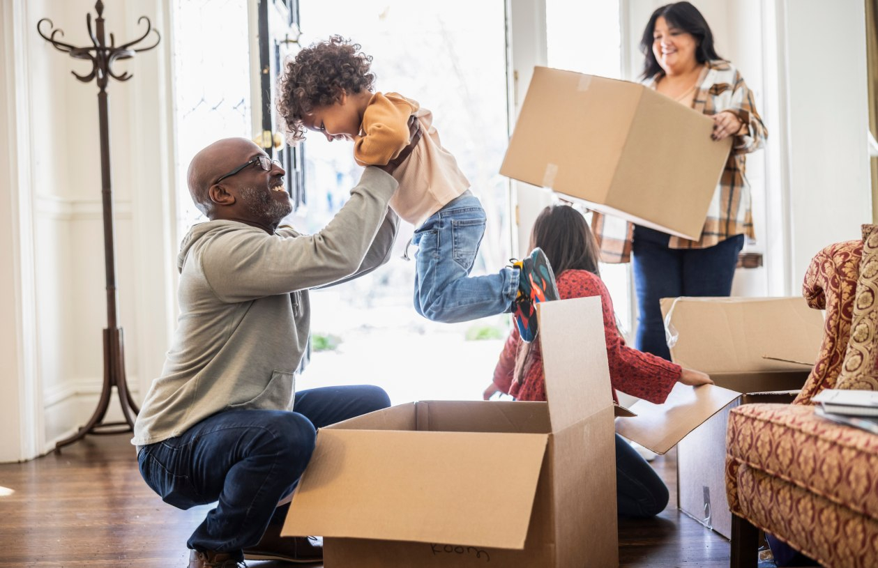A family moving into their new home surrounded by cardboard boxes