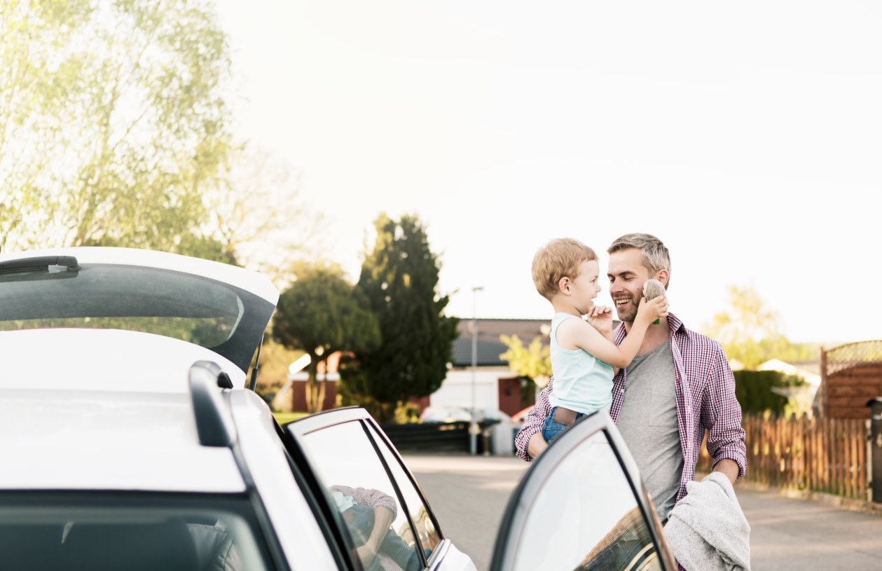 Father and son enjoy their new car