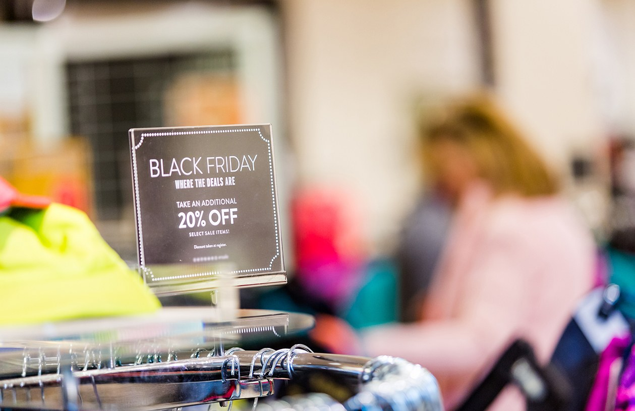 black Friday sales sign on top of clothing rack
