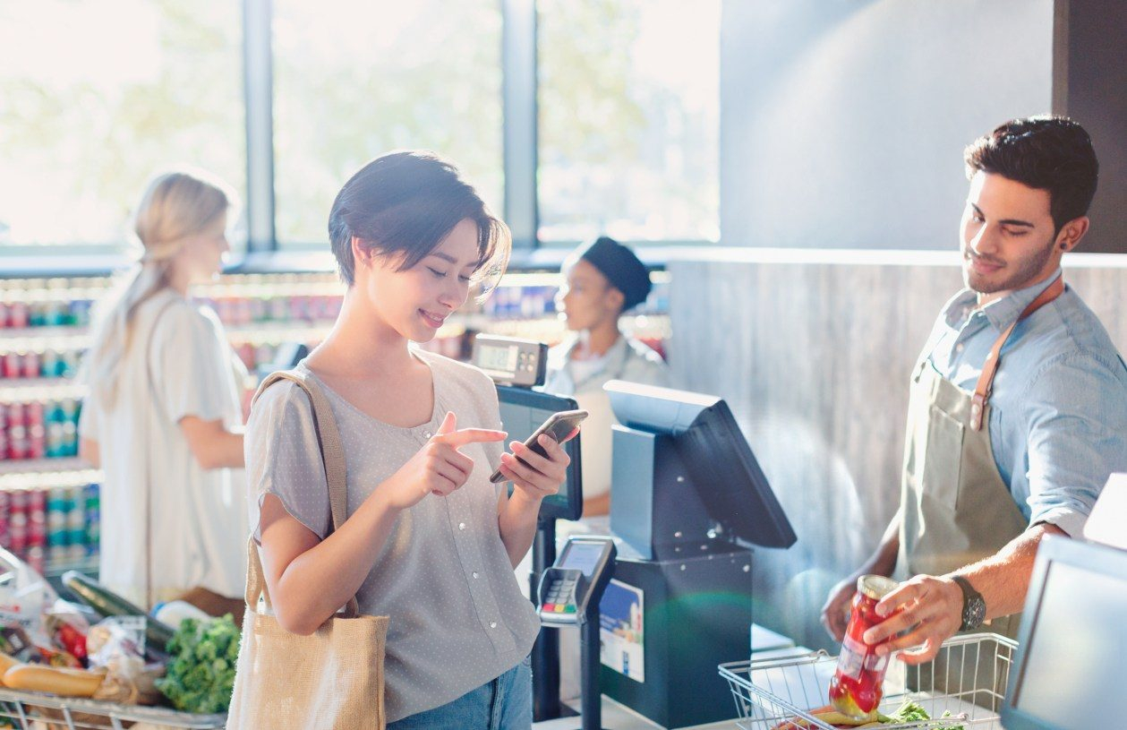 Woman uses a mobile wallet at a grocery store