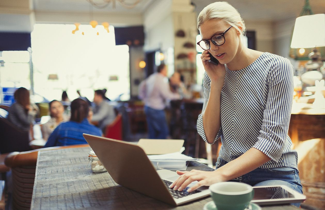 woman freelancer manages her finances working on her laptop in a coffee shop