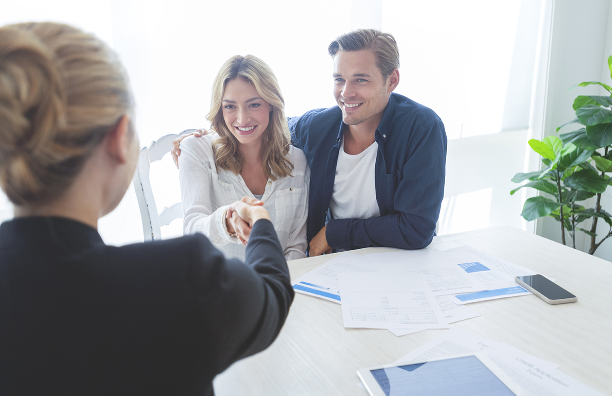 woman and man closing on new home with real estate attorney