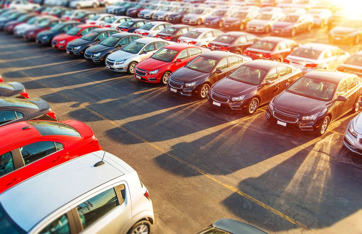 brand new cars in the dealership car lot 
