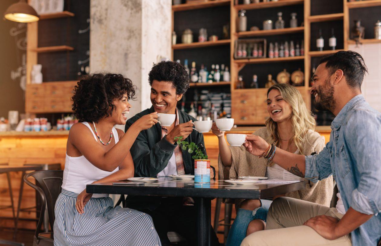 Four friends in a café talking over coffee