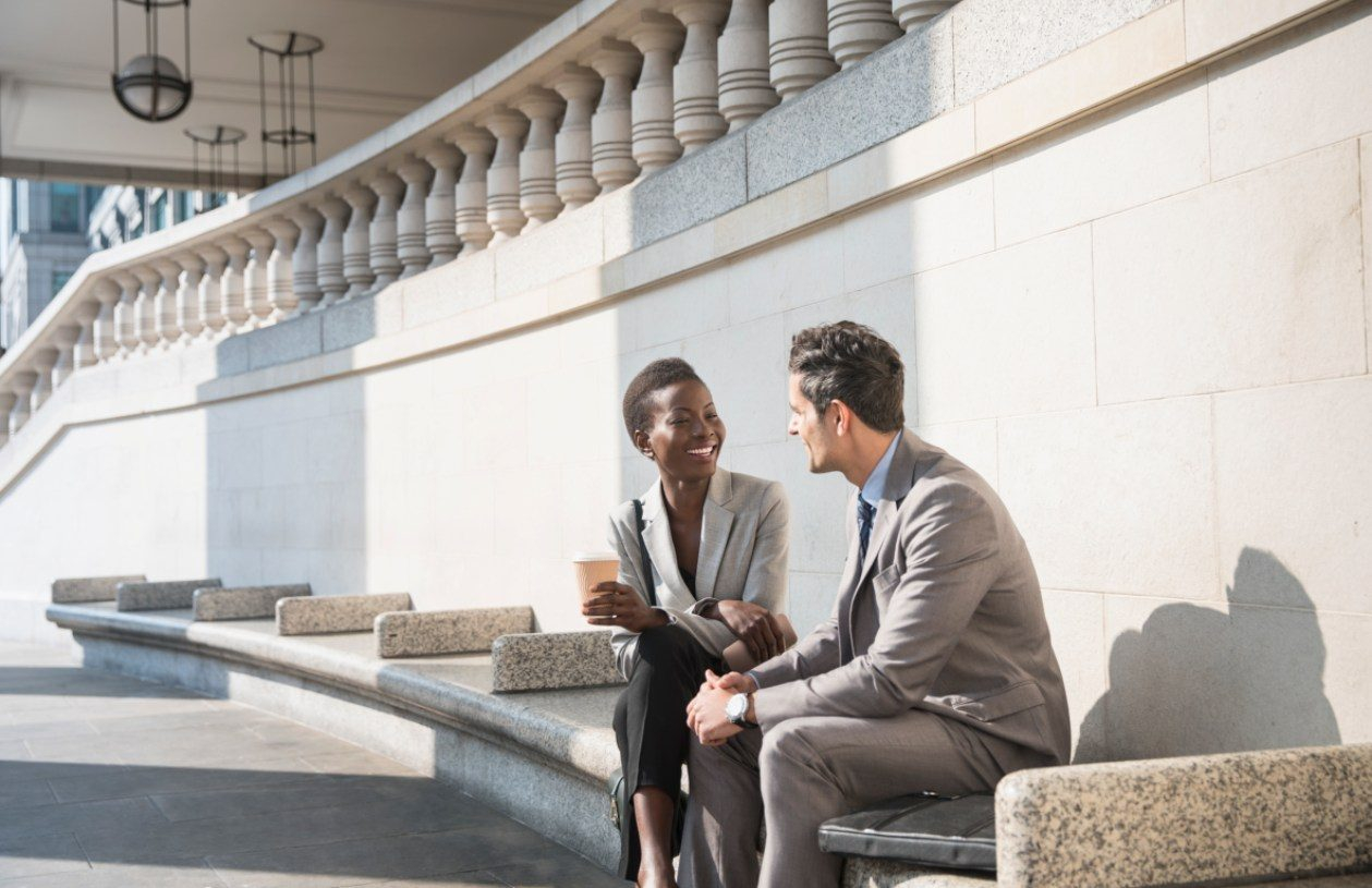 A man and a woman negotiate salary over coffee.