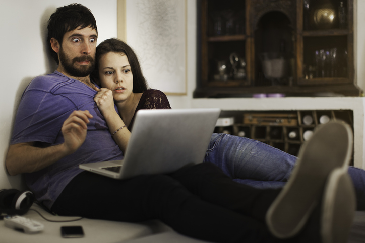Husband and wife appear scared while they look at laptop as they face their financial fears.
